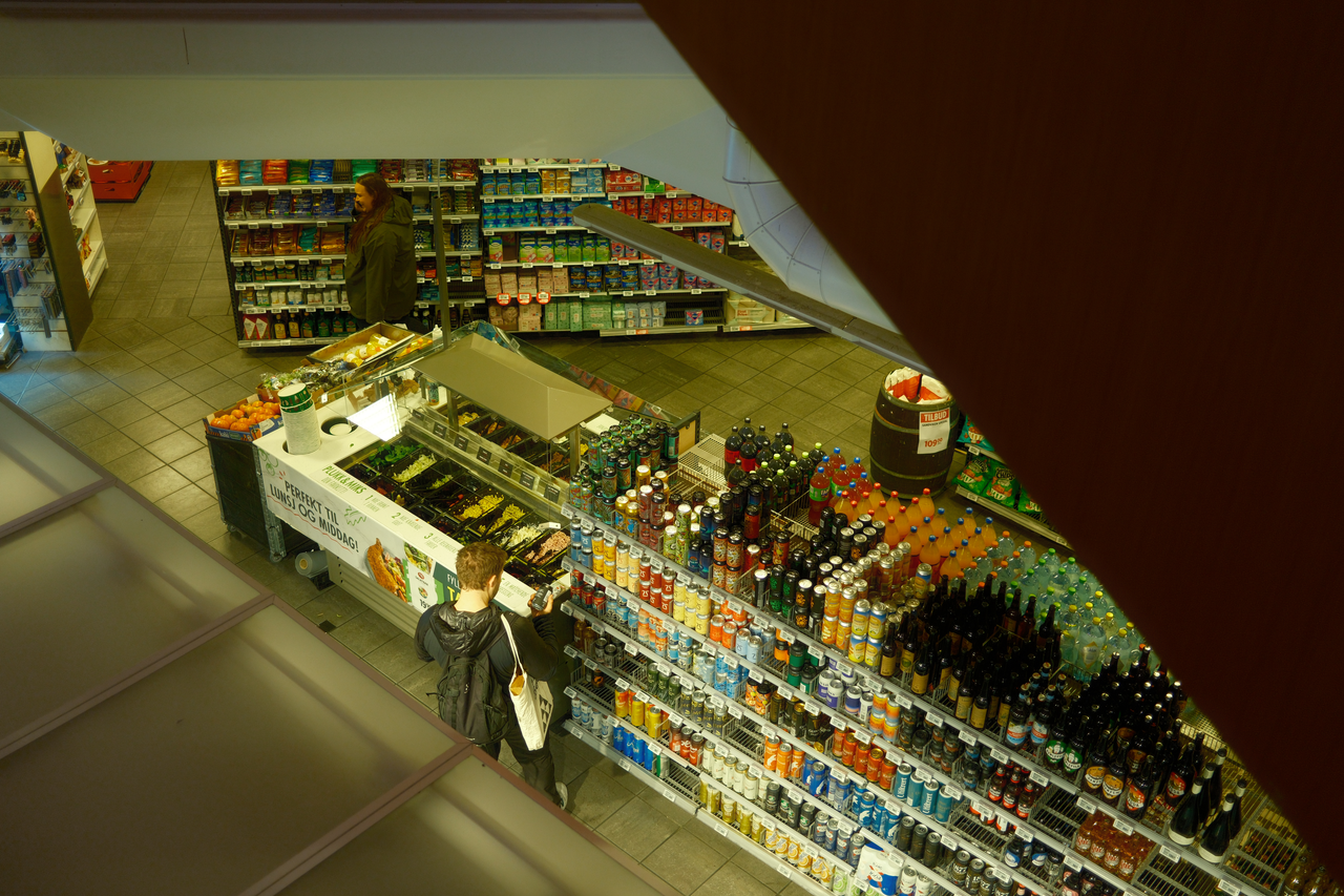 Overhead shot of a grocery store showing customers browsing the beverage aisle.